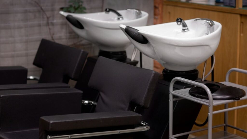 Modern hair salon interior with styling chairs and washing stations.