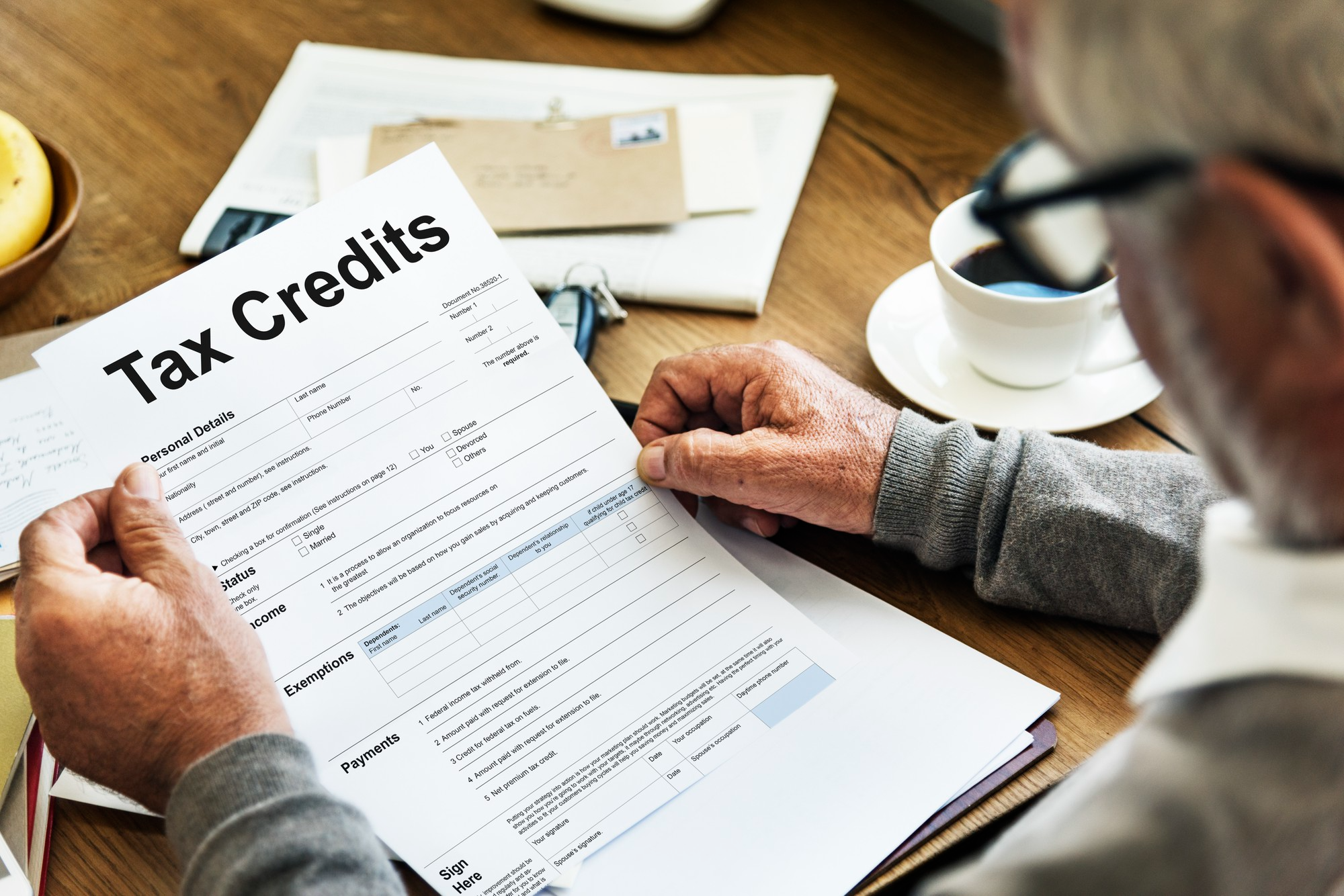Business owner reviewing a tax credits form to identify eligible tax savings for a small business.