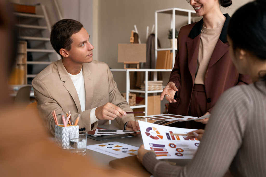 Team members discussing marketing reports and design materials during a business strategy meeting.