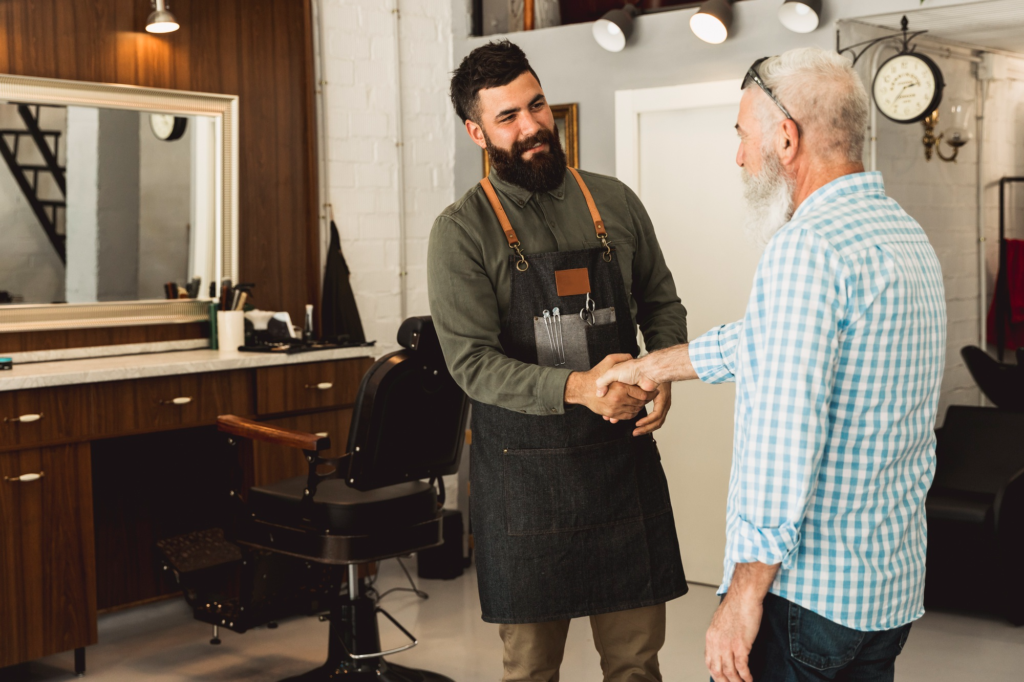 Barber greeting a satisfied client after a successful haircut.