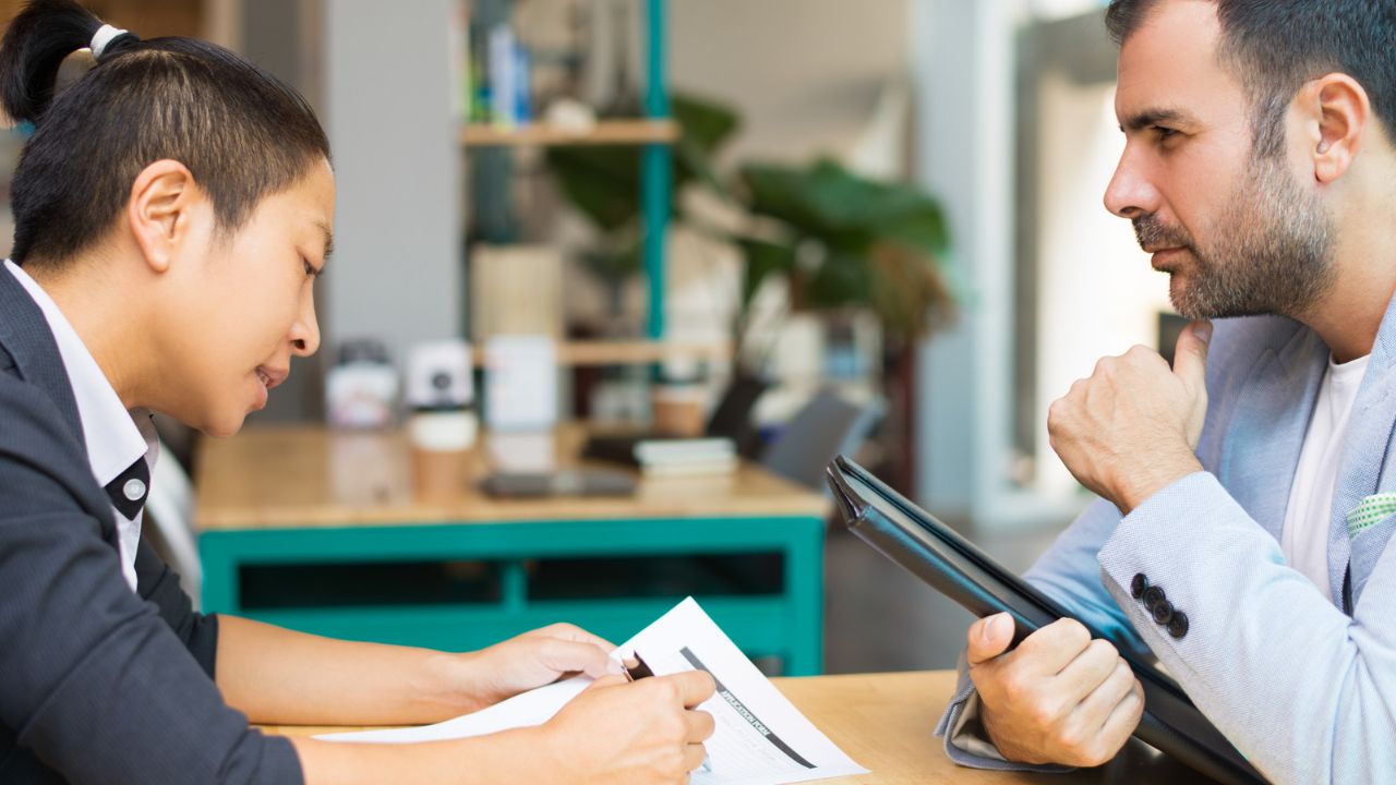  Business professionals discussing documents and planning during a salon management consultation.