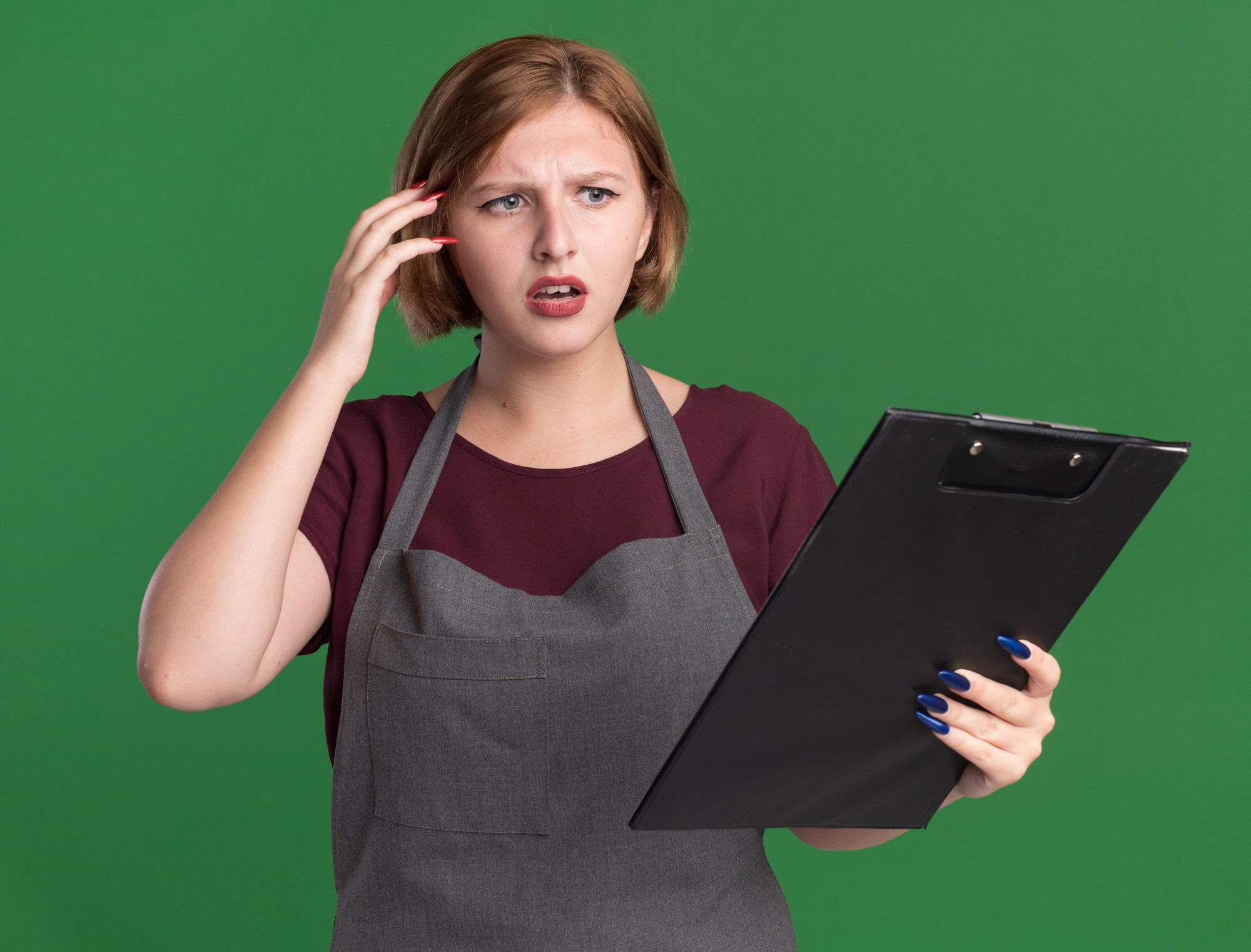 Concerned salon owner reviewing paperwork on a clipboard while checking business expenses, accounting records, and potential financial errors.