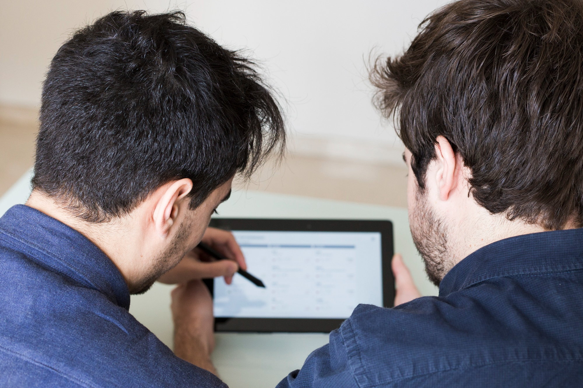 Two professionals reviewing financial records and business data together on a tablet.