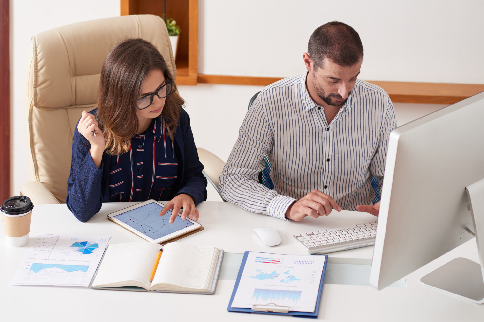 Business professionals analysing financial reports and accounting data together in an office.